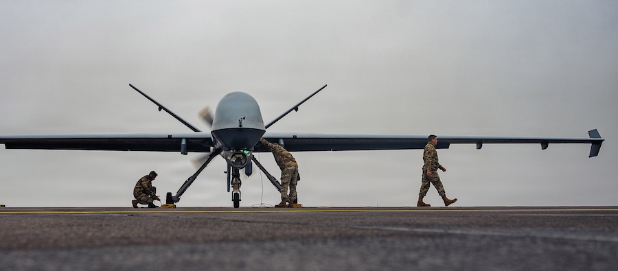 3 airmen working around a Reaper drone