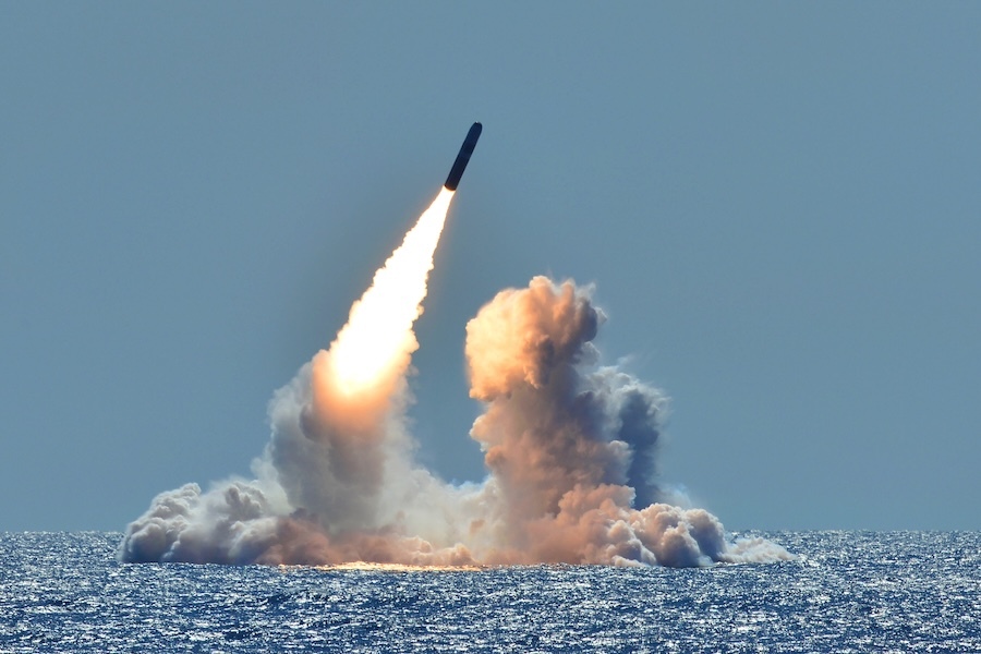 a missile launching from the sea in a cloud of smoke