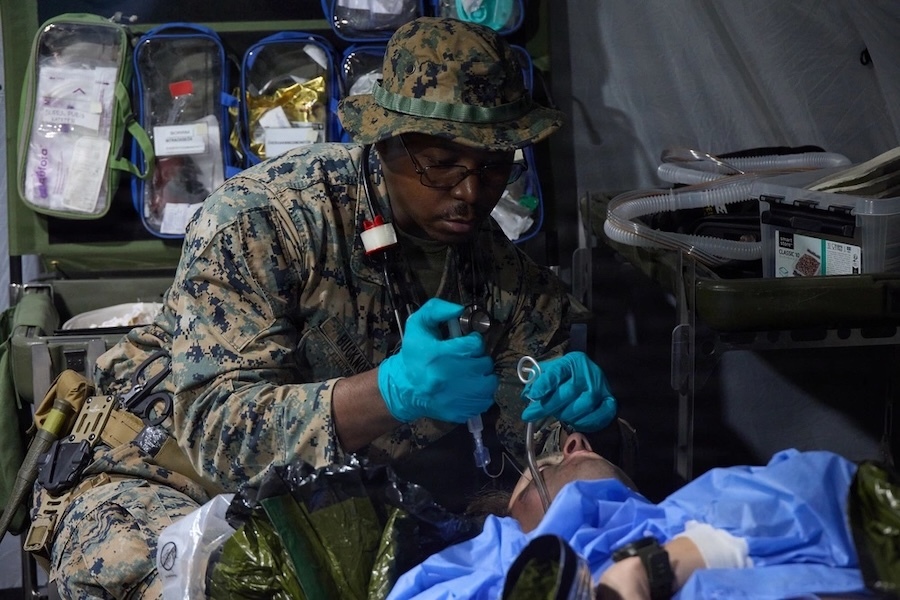 man in fatigues treats a patient