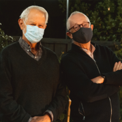 Robert Wilson and Paul Milgrom pose for a pre-dawn photo while wearing masks.