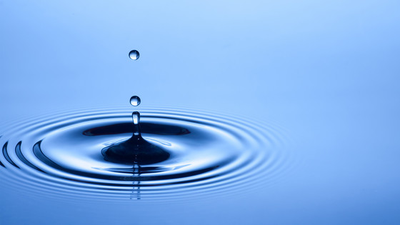 Ripples in water caused by falling droplets.