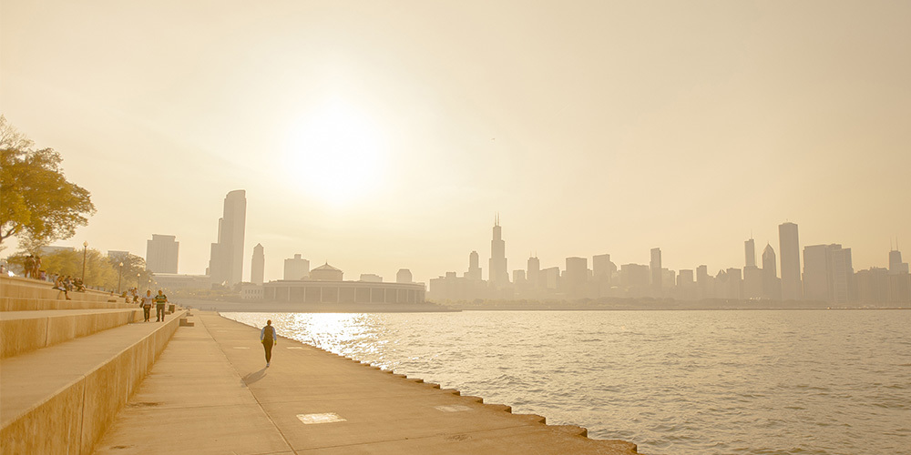 People walk along the lake near Chicago on a hot summer day