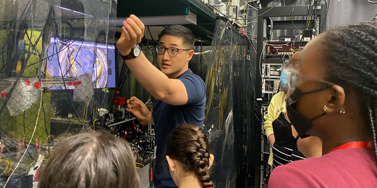Scientist showing quantum science lab to tour group