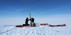Two people working with a yellow ice corer