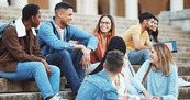 College students sitting on stairs outside. Adobe Stock/S Fanti/peopleimages.com