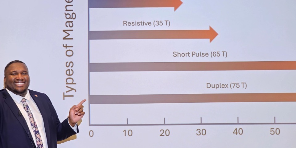 Avery Blockmon standing in front of a screen during his dissertation defense.