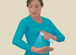 Woman spraying insect repellent