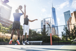 Image shows two Black men playing basketball