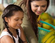 Image shows a Hispanic/Latina mother and daughter shopping for healthy food