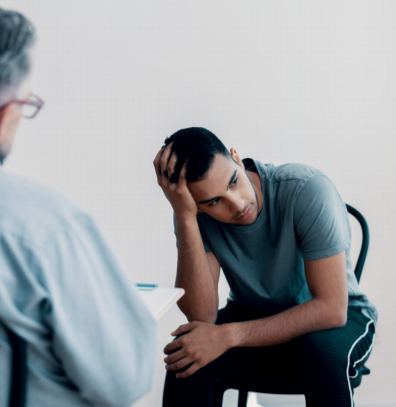 Image shows a young man of colour at a counselling session