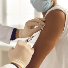 Image shows a health professional administering a vaccine