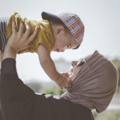 Image shows a Muslim mother and child playing