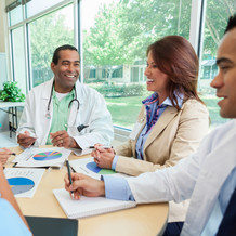 Image shows a team of health professionals around a table