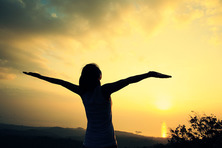 Image of a woman with her arms triumphantly in the air.