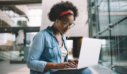 Image of a young woman browsing the internet on a laptop.