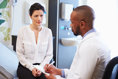 Image of a woman chatting with her physician in a clinic.