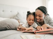 woman and child reading on bed