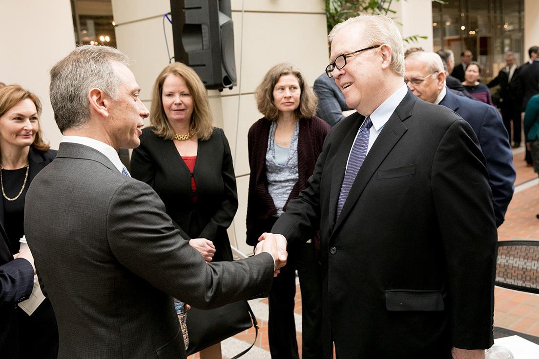 Director Andrei Iancu shakes hands with former Director Q. Todd Dickinson at a USPTO event on Feb. 18, 2018.