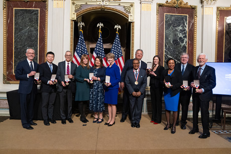 Group of men and women standing side by side holding medals