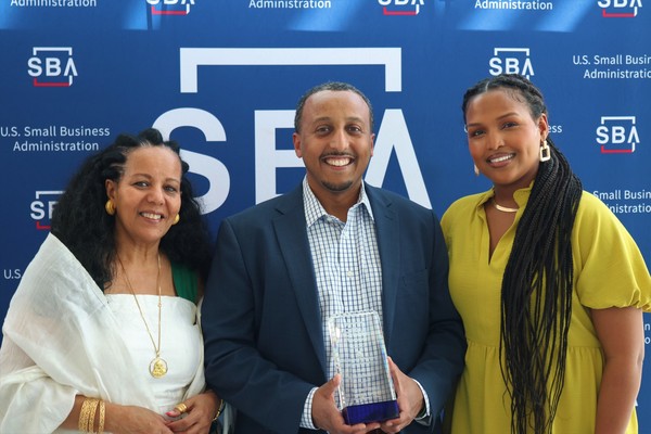 Efrem Fesaha accepts his award. His mother is on his right, his wife on his left