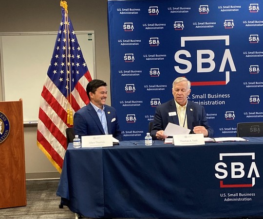 Two men sitting at table with SBA logo
