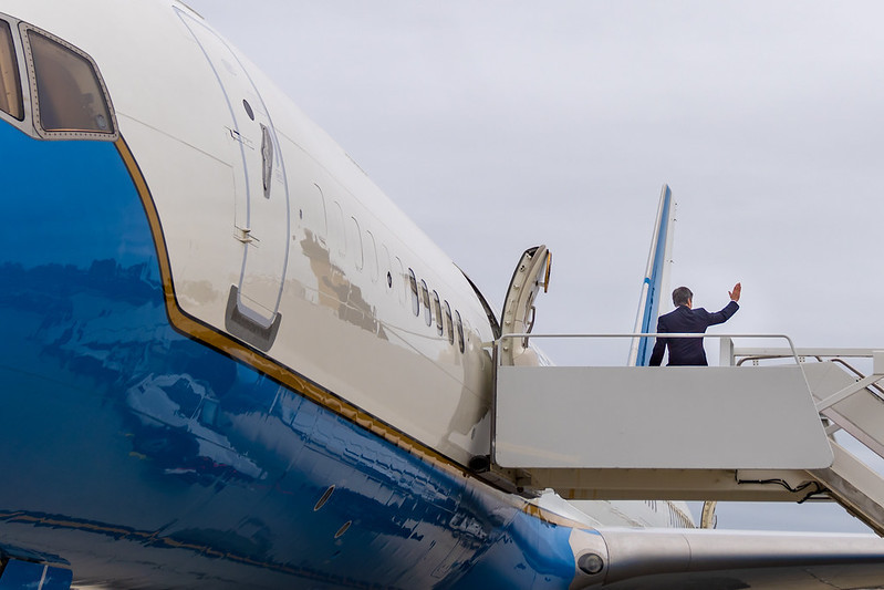 Secretary Blinken waves as he boards a plane. 