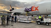 People load cargo into a Fedex plane.