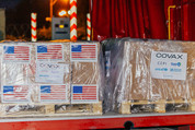 Shipping boxes with 6 American flags and a COVAX label.