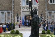 The secretary speaking at a Bastille Day event at the French ambassador’s home in Washington, D.C. with a Statue of Liberty replica shown. 