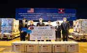 Image of six people holding a COVAX banner labeled “The U.S. provides 1,008,000 doses of Johnson & Johnson vaccine to Lao PDR” with COVAX boxes.