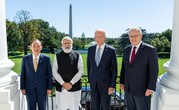 Prime Minister Morrison, President Biden, Prime Minister Modi, and Prime Minister Suga stand outside with the Washington Monument in the background.