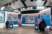 President Biden and Secretary Blinken sit facing a screen that reads “Meeting on Afghanistan” with a collage of video conference participantss.