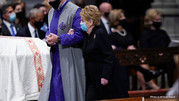 Former Secretary of State Madeleine Albright walks arm-in-arm with someone as she approaches the casket of Secretary of State Colin Powell. 