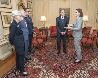 Ms. Tsikhanouskaya gestures as she meets with Secretary Blinken, Deputy Secretary Sherman, and others in an official meeting room.