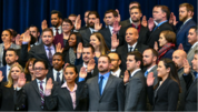 A group of people raising their right hand to be sworn into the Foreign Service. 