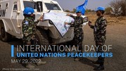 Photo of three UN peacekeepers and an armored vehicle and the text 