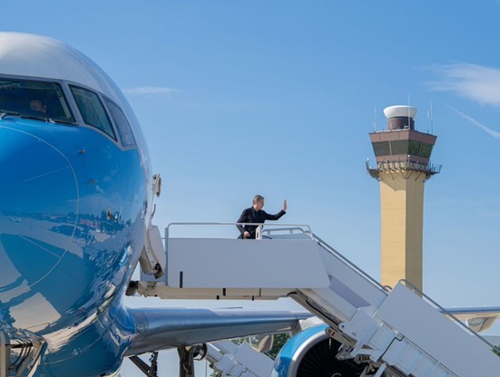 Secretary Blinken waves as he is about to board his plane to start his travels.