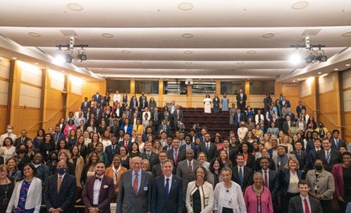 Secretary Binken stands in the middle of a group photo in an auditorium with Pickering, Rangel, Payne, FAIT, Powell Fellows