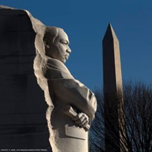 MLK Memorial in Washington, D.C. with Martin Luther King Jr. sculpted in stone, with his arms crossed, and the Washington Monument