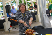 U.S. Ambassador to Suva Marie Damour wearing a white and black dress carving a turkey. 