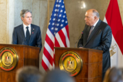 Secretary Blinken listens as Foreign Minister Shoukry stands behind a lectern and speaks into a microphone. 