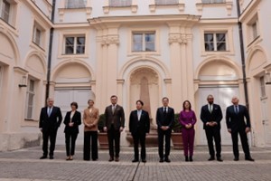 Secretary Blinken meets with G7 foreign ministers stand in a cobblestone courtyard in front of a pale yellow, historic building.