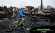 A man, wearing a hat and a bright blue parka, walks a green bicycle alongside burned out tanks and damaged buildings. 