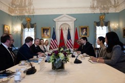 Secretary Blinken and U.S. and Moroccan officials are seated around a large, white table in a formal room with U.S. and Morocco flags in background. 