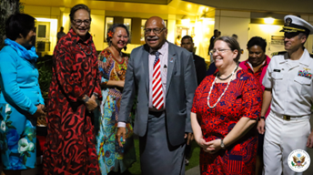 Ambassador Damour smiles while walking with Prime Minister Rabuka to the Independence Day event with attendees smiling beside them. 