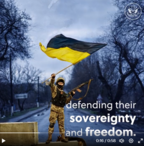 Screenshot from a video showing a person in military clothing waving the Ukrainian flag and holding a weapon.