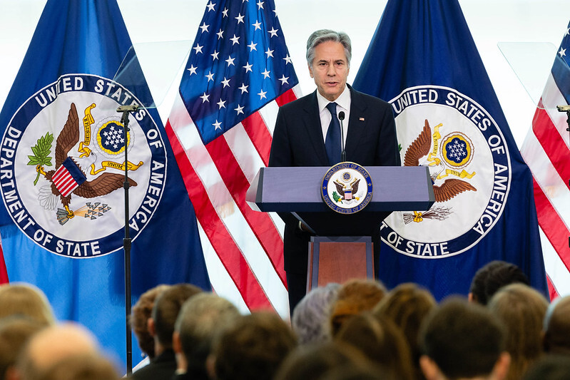 Secretary Blinken discussing our Modernization Agenda from behind a lectern with the American and State Department flags at his back.