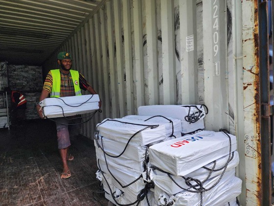 A member of the Vanuatu Red Cross moving boxes of USAID relief supplies.