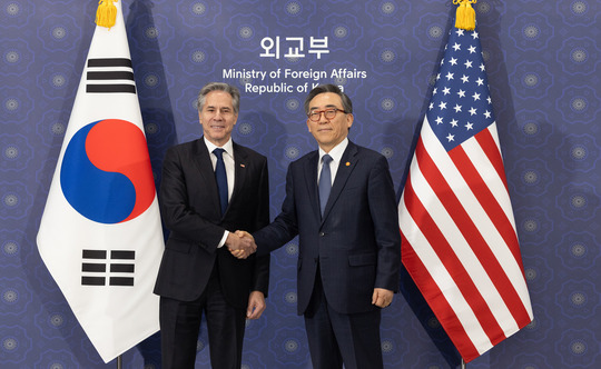 Secretary Blinken shakes hands with Republic of Korea Foreign Minister Cho Tae-Yul in front of flags.