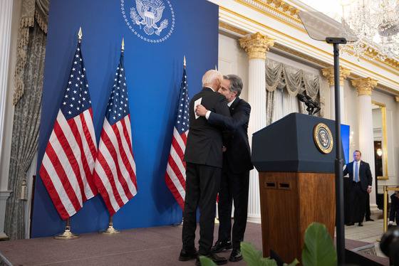 President Joe Biden and Secretary Antony Blinken embrace next to a lectern at the Department of State January 13, 2025. (Official State Dept. photo)
